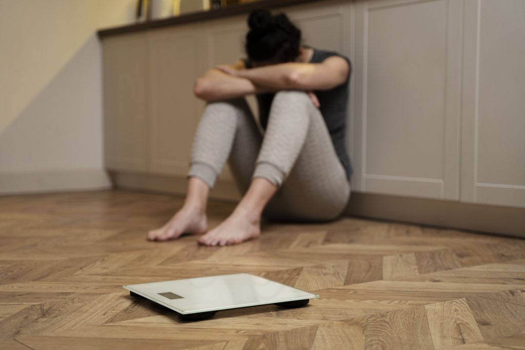 femme pleurant à côté d'une balance